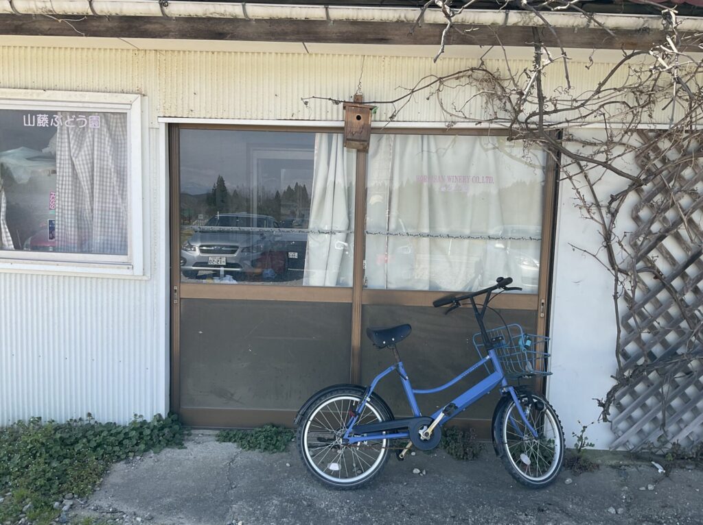 戸口の前に停めてある青いキレイな自転車