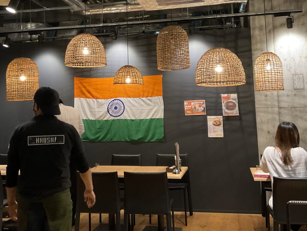 インド料理の店内、照明、テーブル、人の後ろ姿
