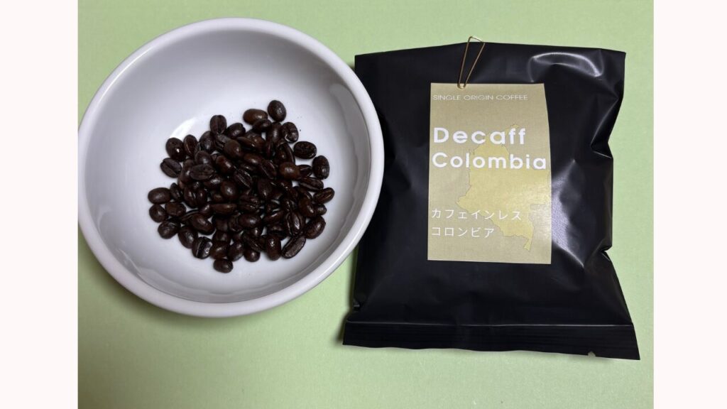 マウンテンコーヒーデカフェコロンビアのパッケージと小皿に入れたコーヒー豆の写真。