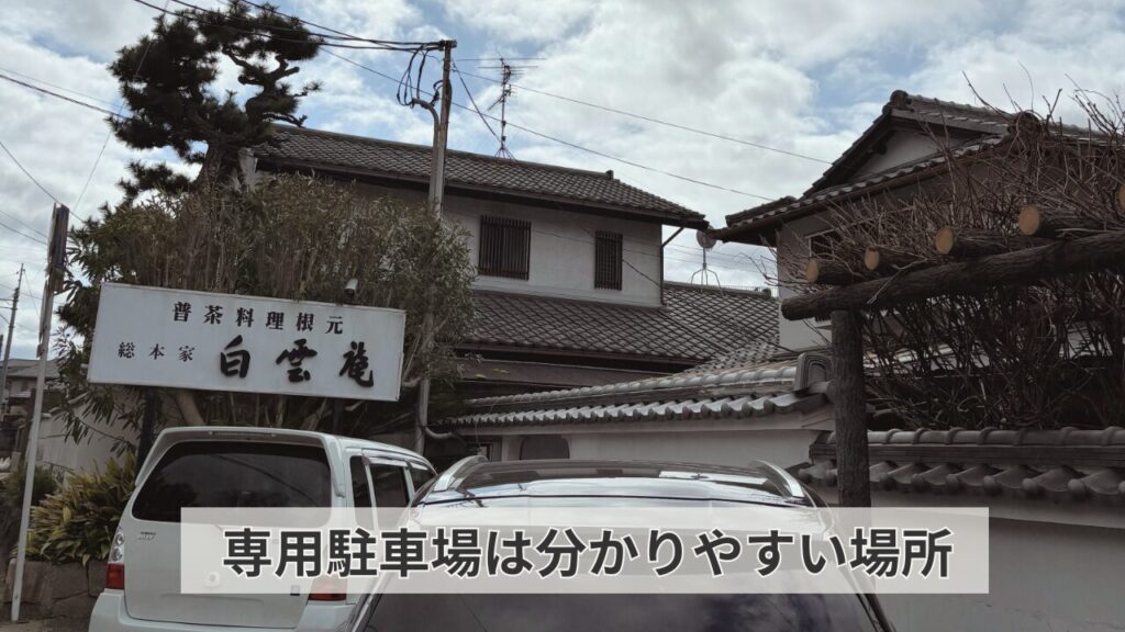 白雲庵の店の看板と駐車場に車が２台駐車されている写真。