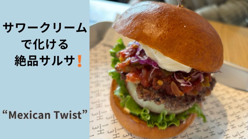 石川県野々市市のハンバーガーショップ「1/3 HAMBURGER FACTORY」バンズに挟まれた肉感のあるパティと白いサワークリーム、赤いサワークリームが美味しそうな写真。